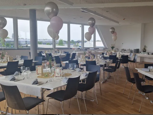 Offene Fensterfront mit Blick auf eine grüne Landschaft, sorgt für eine lichtdurchflutete, inspirierende Atmosphäre in der Eventlocation.